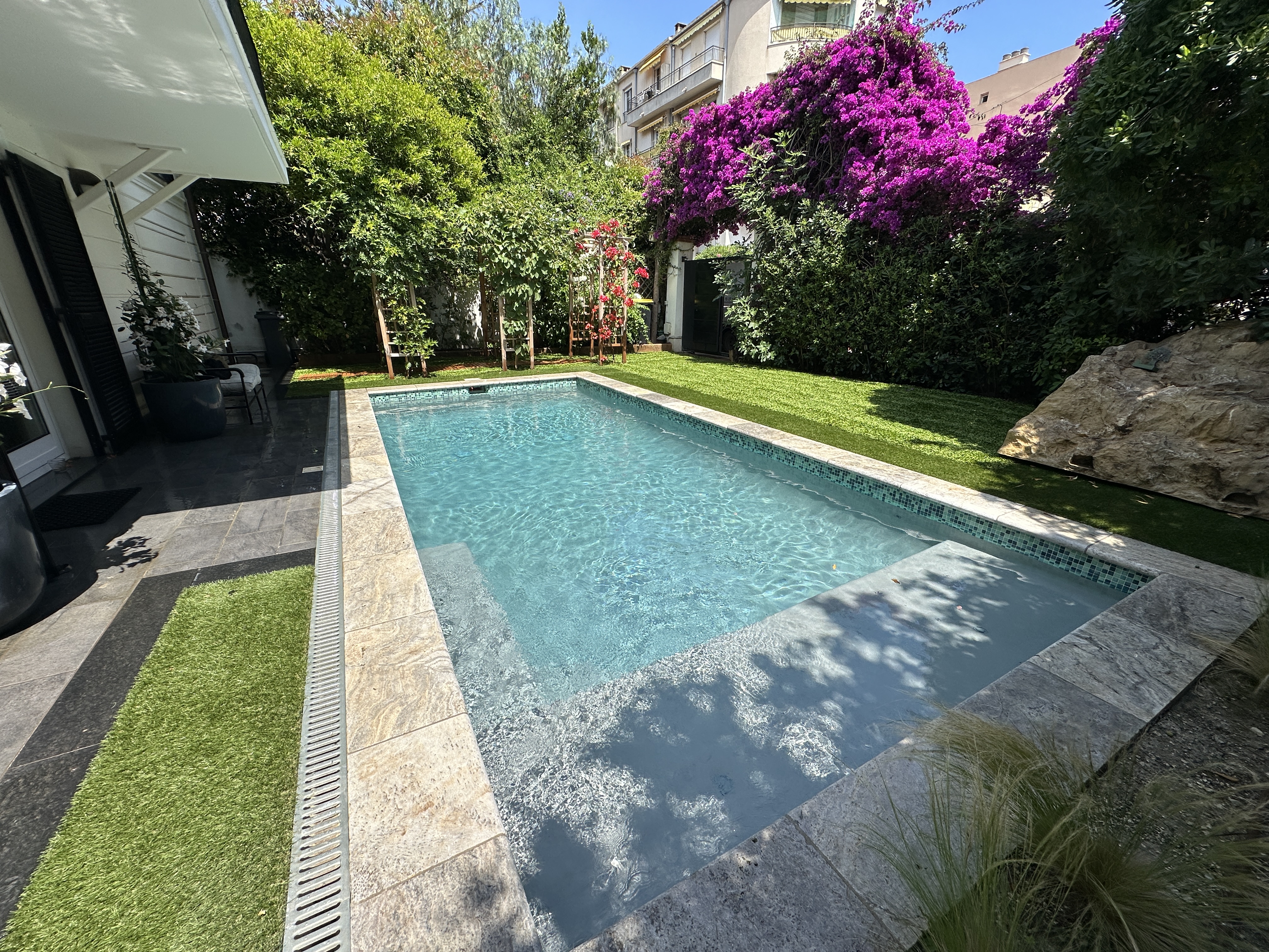 Société de démoustication : Technicien Nazarian appliquant une pulvérisation anti-moustique tigre dans un jardin paysager d'une villa sur la Côte d'Azur